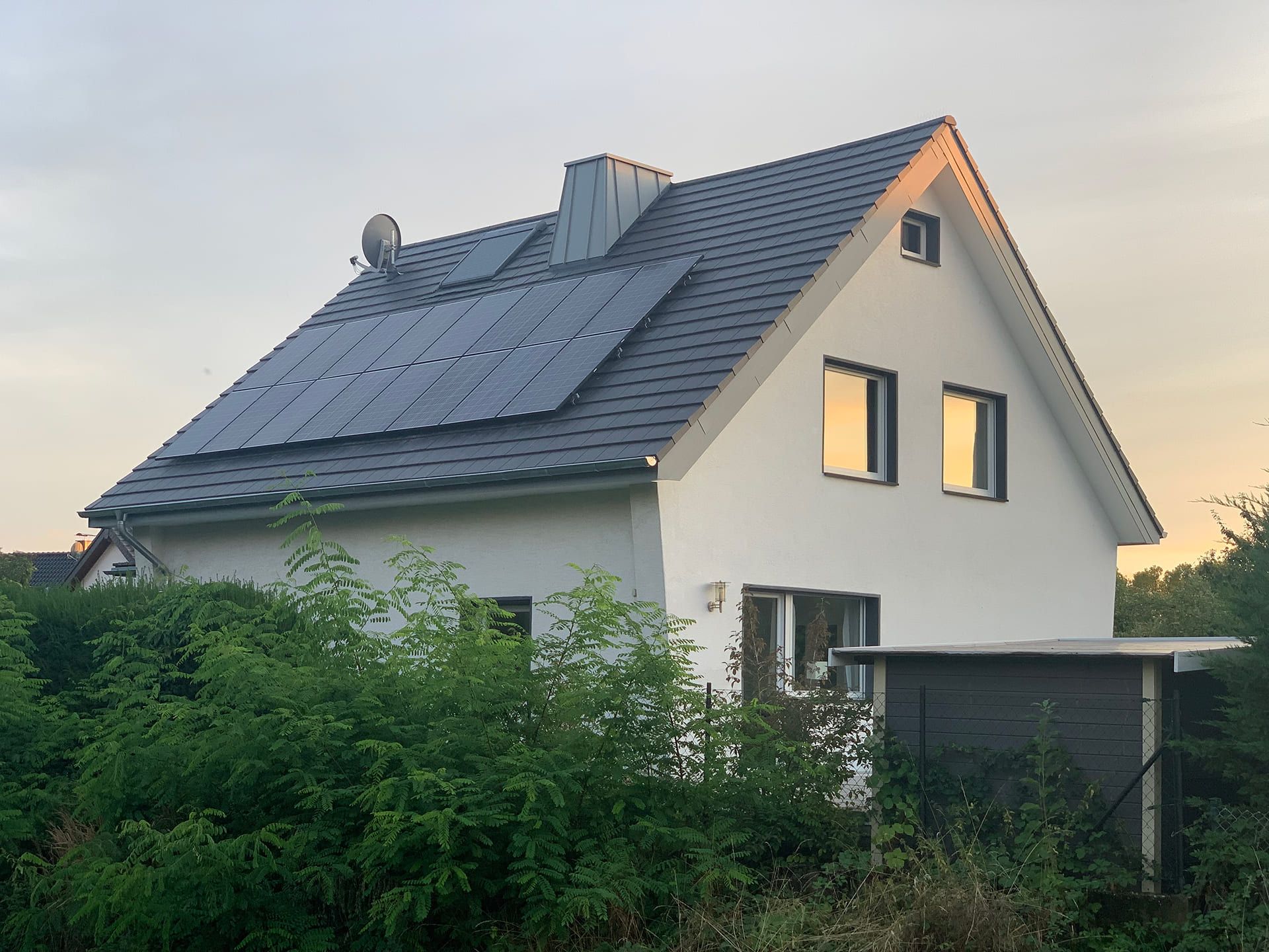 Ein Haus mit Solarpanelen auf dem Dach, das umweltfreundliche Energie erzeugt.
